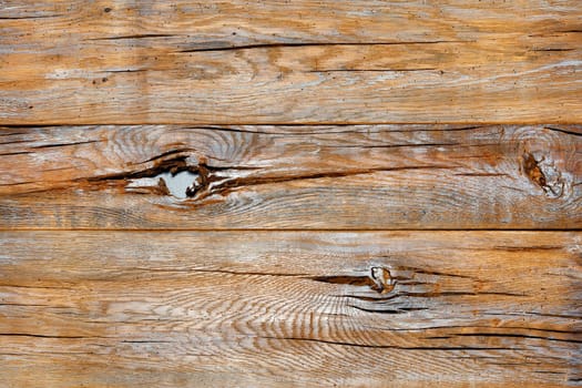 Old wood background from cracked planks with brown texture with spots of knots and scuffs in high resolution.