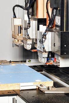 Pneumatic line of automatic drilling and milling machine for the manufacture of cabinet furniture from chipboard. Vertical image, selective focus.