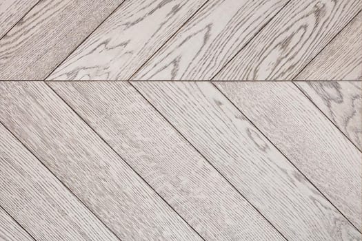 Light wood planks with a expressive gray texture are neatly stacked side by side.