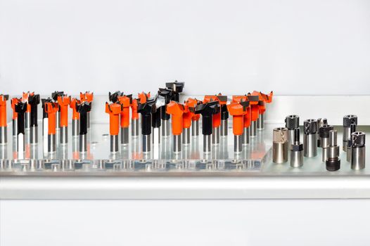 Carbide cutters and collet chucks are inserted vertically in the woodworking kit and are used in automated woodworking machines, close-up, copy space.