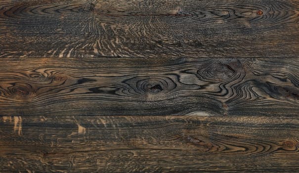 Old wooden background from dark brown horizontal planks texture with grains, cracks and knots.
