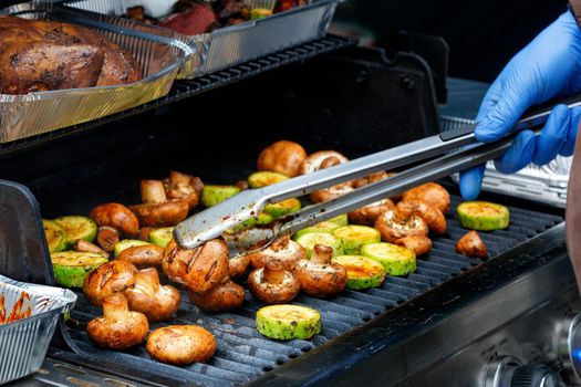 Delicious mushrooms champignons and green zucchini are grilled close-up, selective focus.