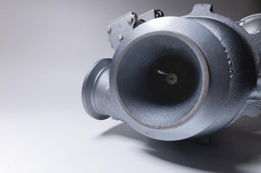 New turbocharger with aluminum cold section. on a gray contrasting background. car engine turbocharger. spare parts.