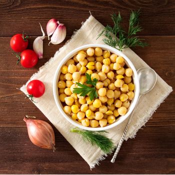 Cooked Chickpeas on bowl on a dark wooden table. Healthy, vegetarian nutritious protein food of Middle East. Top view.