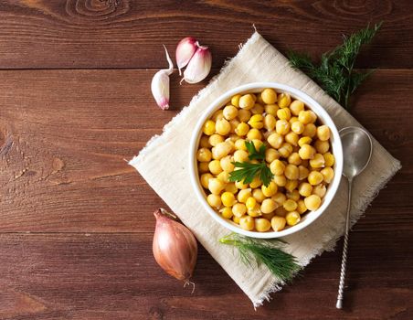 Cooked Chickpeas on bowl on a dark wooden table. Healthy, vegetarian nutritious protein food of Middle East. Top view.