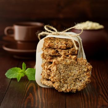 Homemade oatmeal cookies with banana, oats, nuts, eggs and flour free on a brown dark wooden table, side view.