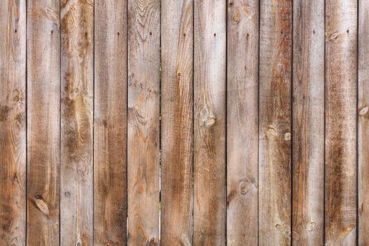 A simple and unvarnished wood fence made from untreated wood with a rough texture and rusty nails.