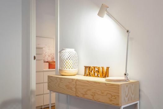 Table lamp, candle holder and wooden word Dream at home with a room at the background
