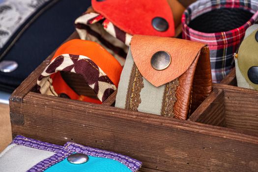 Handmade women's bracelets, made of leather and fabric, with metal rivets, on a store shelf. Fashion accessory