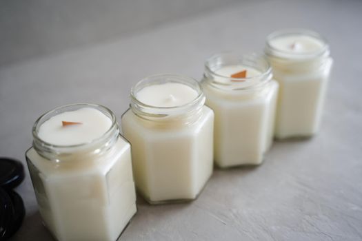 A set of candles made of natural soy wax in glass jars. Candles with wooden crackling wicks and cotton reinforced wicks. Scented container candles.