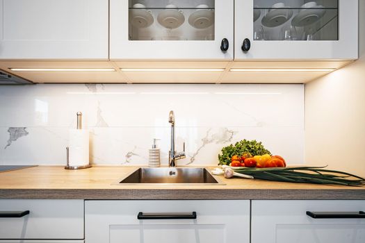 Vegetables on the table in the kitchen tap and sink. High quality photo