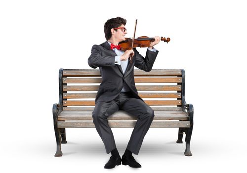 Young businessman plays the violin sitting on a wooden bench. Inspiration in business