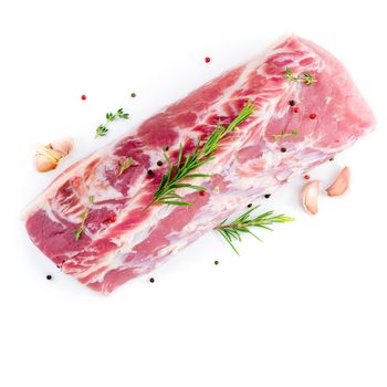 large piece of meat, raw pork carbonate fillet isolated on a white background, with rosemary and garlic seasonings, top view