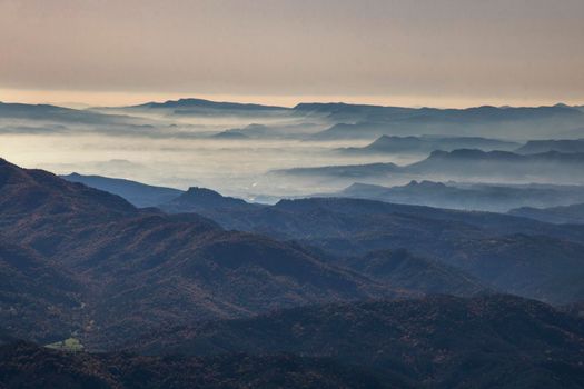Misty foggy landscape showing layers of mountains from a peak called Taga