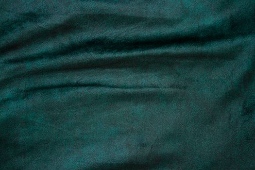 velour fabric texture, background, green. Velvet velour cloth background with glowing light and dark shadows. Background for theater and fashion design themes.