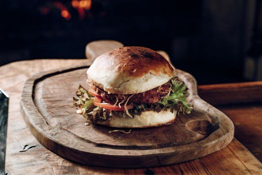 Hamburger on a black background on a wooden stand. High quality photo