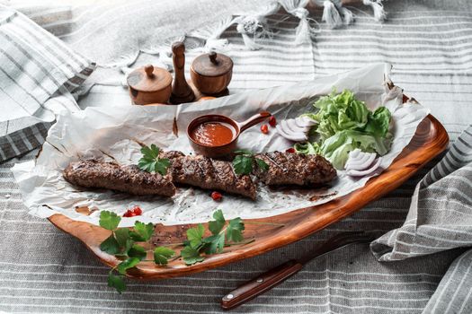 Kebab with sauce and greens on a plate. High quality photo
