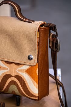 Handmade leather women's bag of brown, orange and beige colors. Fashion and craft concept