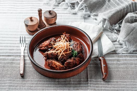 Fried wings in a clay plate on a grey tablecloth. High quality photo