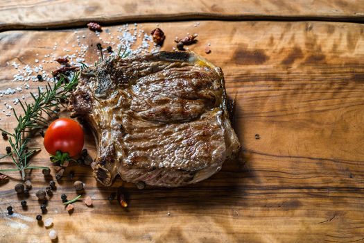 Fried steak on the bone on a wooden surface soul and pepper. High quality photo