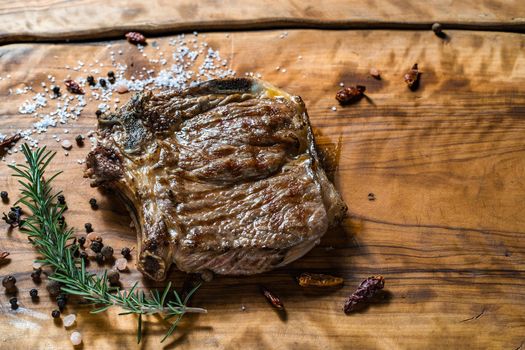 Fried steak on the bone on a wooden surface soul and pepper. High quality photo