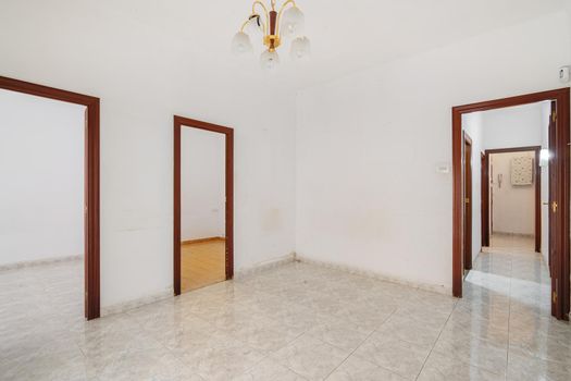 Empty white hall with long corridor and doors leading to other rooms. Typical apartment in Barcelona for rent or sale