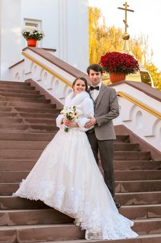 Newlyweds on the steps near the Orthodox Church