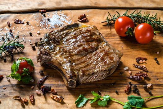 Fried steak on the bone on a wooden surface soul and pepper. High quality photo