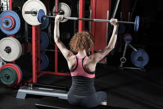 Woman bodybuilder engaged with a barbell in the gym. Healthy lifestyle.