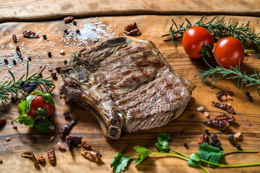 Fried steak on the bone on a wooden surface soul and pepper. High quality photo