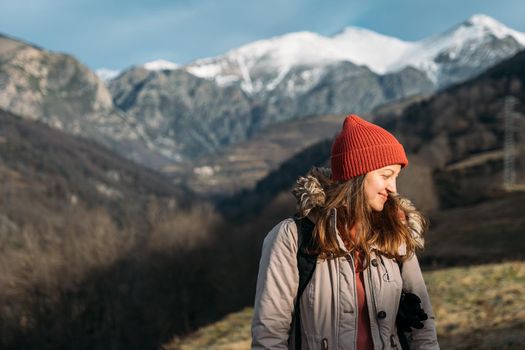 A portrait of a traveler. Women hiking woman happy and smiling, pulling her cap over her eyes and throwing her head back laughs while hiking in the mountains.