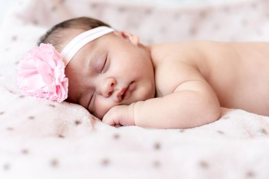 Childhood, care, motherhood, health, medicine, pediatrics concepts - Close up Little peace calm naked infant newborn baby girl in pink hat sleeps resting take deep nap laying on tummy on soft bed.