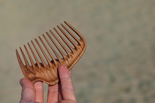 Handmade wooden comb for head massage and hair combing. Hair care concept