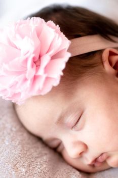 Childhood, care, motherhood, health, medicine, pediatrics concepts - Close up Little peace calm naked infant newborn baby girl in pink hat sleeps resting take deep nap laying on tummy on soft bed.