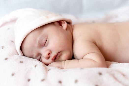 Childhood, care, motherhood, health, medicine, pediatrics concepts - Close up Little peace calm naked infant newborn baby girl in pink hat sleeps resting take deep nap laying on tummy on soft bed