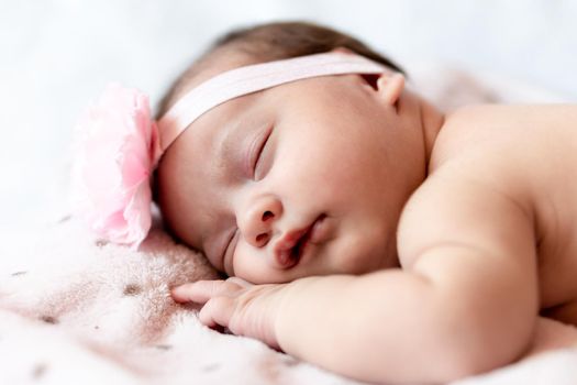 Childhood, care, motherhood, health, medicine, pediatrics concepts - Close up Little peace calm naked infant newborn baby girl in pink hat sleeps resting take deep nap laying on tummy on soft bed.