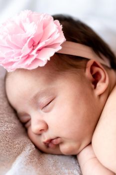 Childhood, care, motherhood, health, medicine, pediatrics concepts - Close up Little peace calm naked infant newborn baby girl in pink hat sleeps resting take deep nap laying on tummy on soft bed.
