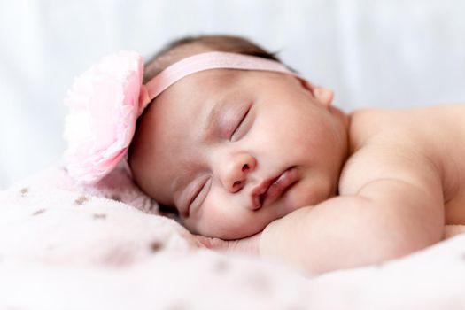 Childhood, care, motherhood, health, medicine, pediatrics concepts - Close up Little peace calm naked infant newborn baby girl in pink hat sleeps resting take deep nap laying on tummy on soft bed.