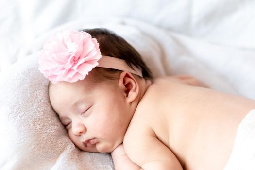 Childhood, care, motherhood, health, medicine, pediatrics concepts - Close up Little peace calm naked infant newborn baby girl in pink hat sleeps resting take deep nap laying on tummy on soft bed.