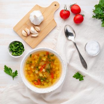 Healthy spring vegetable dietary vegetarian soup, white wooden background, top view, close up.