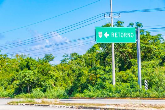 Green turquoise Retorno tun over road sign at the highway from Tulum to Playa del Carmen Quintana Roo Mexico.