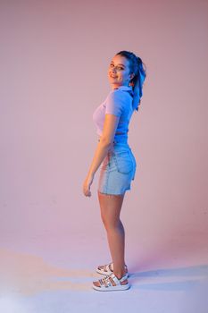 a woman in denim shorts, sunglasses in the studio on an interesting beautiful background.