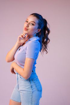 a woman in denim shorts, sunglasses in the studio on an interesting beautiful background.