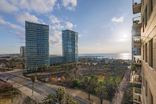 View from a balcony to the public park and sea. Expensive real estate in Diagonal Mar area in Barcelona, Catalonia, Spain.