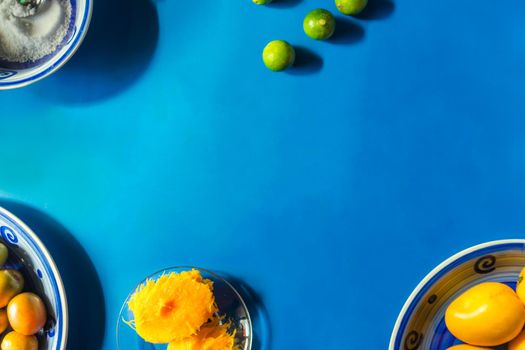 Background with copy space of a blue table with summer fruits such as mangoes and jocotes, traditional summer fruits in Nicaragua, Central America and Latin America.