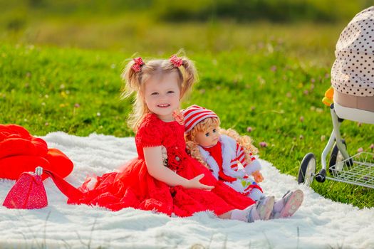 girl playing with a doll sitting in nature