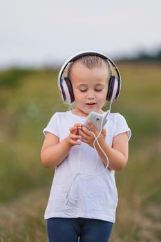 little girl in headphones in nature