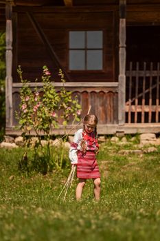 child in a traditional Ukrainian costume is playing in the yard