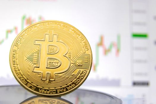 bitcoin coin on the background of the graph close-up