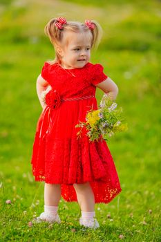 girl in a red dress and flowers on the lawn